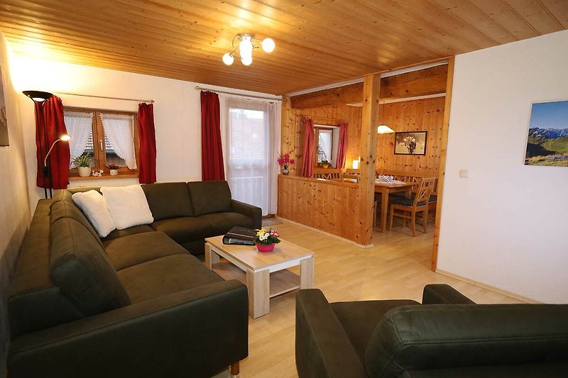 Wohnzimmer mit Couch, TV und Holzmöbeln.