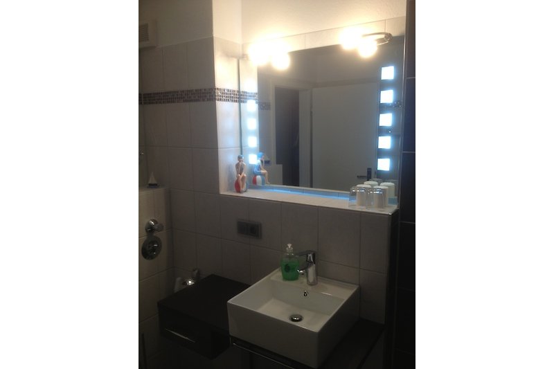 Modernes Badezimmer mit elegantem Spiegel.