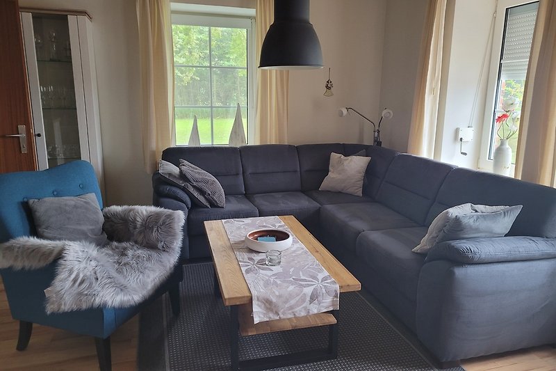 Gemütliches Wohnzimmer mit hellem Holzboden, bequemer Couch und stilvoller Einrichtung.