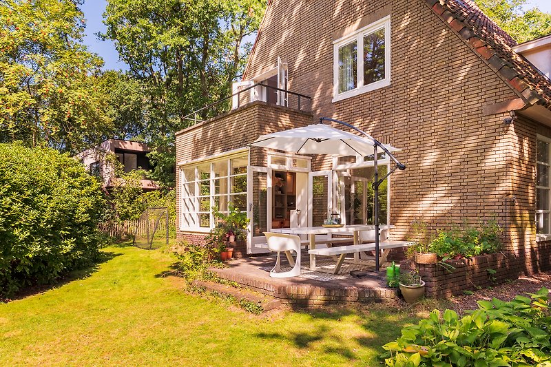 Schöne Villa mit grünem Garten und gemütlicher Veranda.