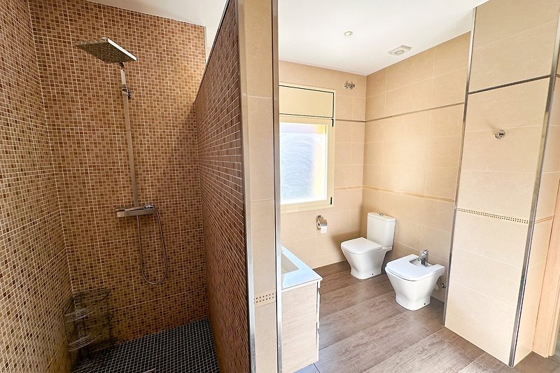 Badezimmer mit lila Duschvorhang, Holzdetails und Glasdusche.