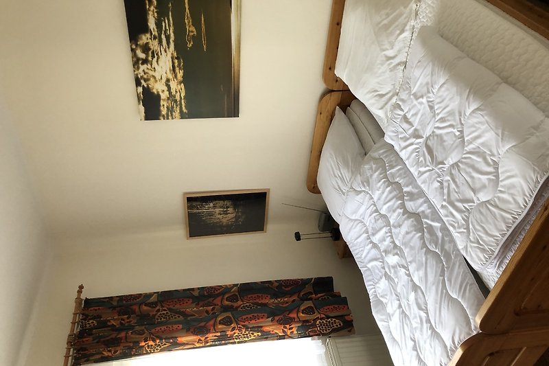Gemütliches Schlafzimmer mit Holzmöbeln, bequemem Bett und Fenster.