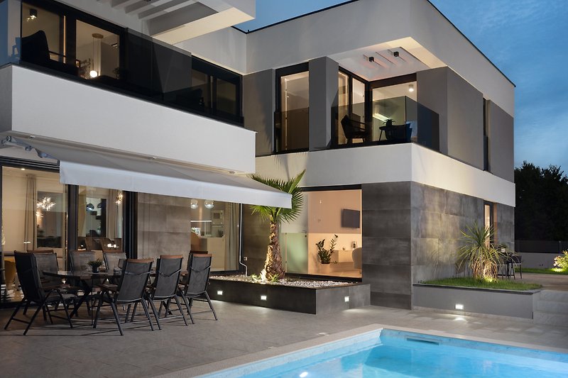 Schönes Haus mit Pool, modernem Design und Blick auf das Wasser.