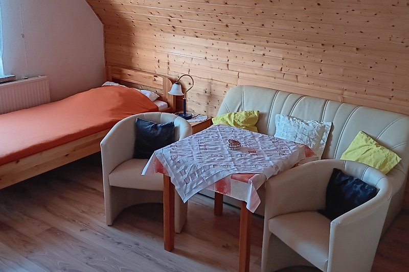 Gemütliches Wohnzimmer mit bequemen Möbeln und Holzboden.