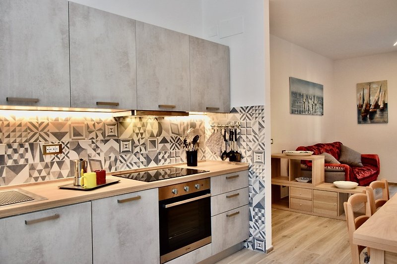 Una cucina moderna con armadi, piano di lavoro e pavimento in legno.