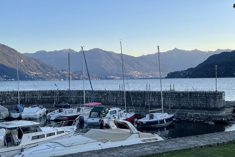 Atemberaubender Seeblick mit Bergen, Segelbooten und Hafen.