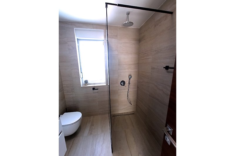 Modernes Badezimmer mit Dusche, Fenster und Holzdetails.