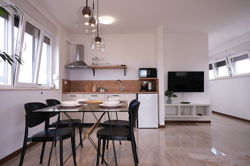 Geräumige Küche mit Holzmöbeln, Fensterfront und stilvoller Beleuchtung.