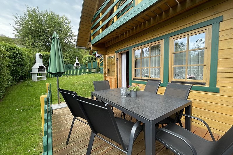 Schöne Terrasse mit Tisch, Stühlen und Pflanzen.