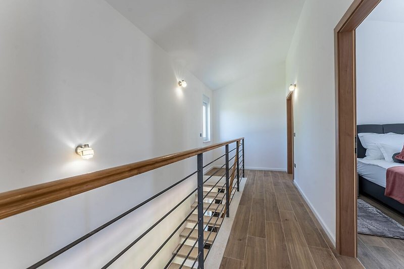 Gemütliche Wohnung mit Holzboden, Treppe und moderner Beleuchtung.