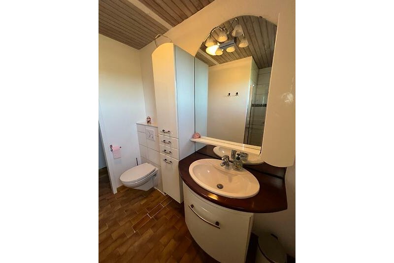 Schönes Badezimmer mit Spiegel, Waschbecken und  Holzschrank.