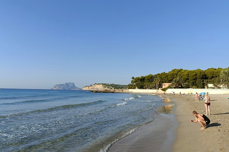 Genießen Sie den Sommer am Strand mit kristallklarem Wasser und goldenem Sand.