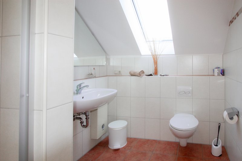 Modernes Badezimmer mit lila Akzenten und elegantem Spiegel.