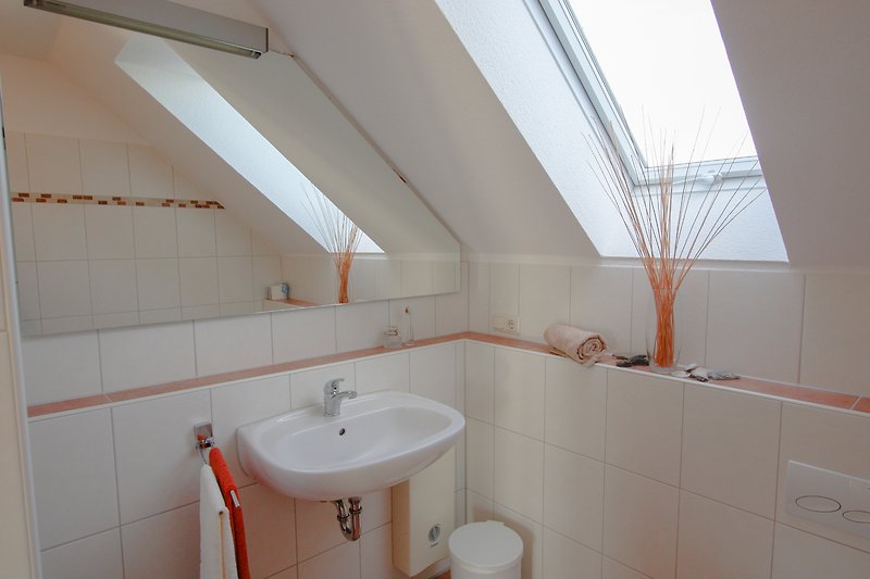 Modernes Badezimmer mit elegantem Spiegel und Holzdetails.