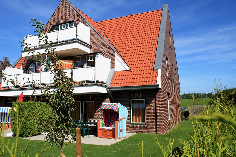 Ländliches Ferienhaus mit Holzfassade und grüner Umgebung.