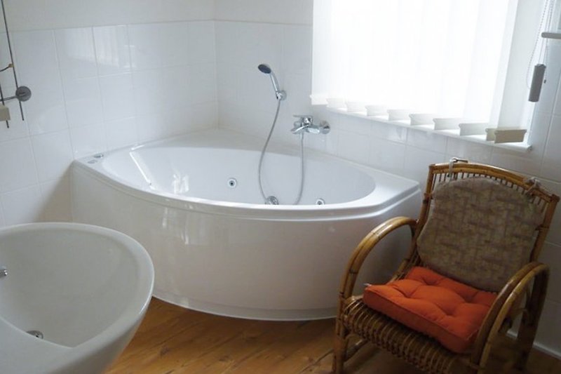 De badkamer op de bovenverdieping is voorzien van een douche en een bubbelbad.