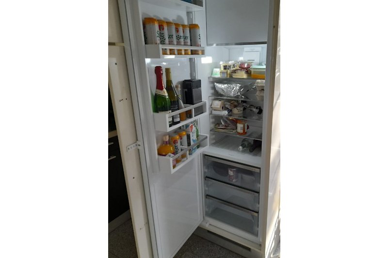 Gemütliche Küche mit Kühlschrank, Gefrierschrank und Küchengeräten.