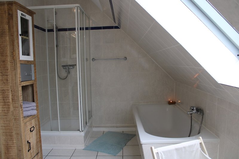 Modernes Badezimmer mit Dusche, Badewanne und Glasduschtür.