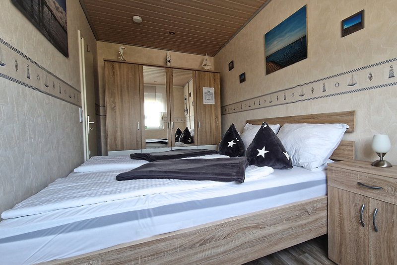 Modernes Schlafzimmer mit stilvollem Bett und gemütlicher Beleuchtung.