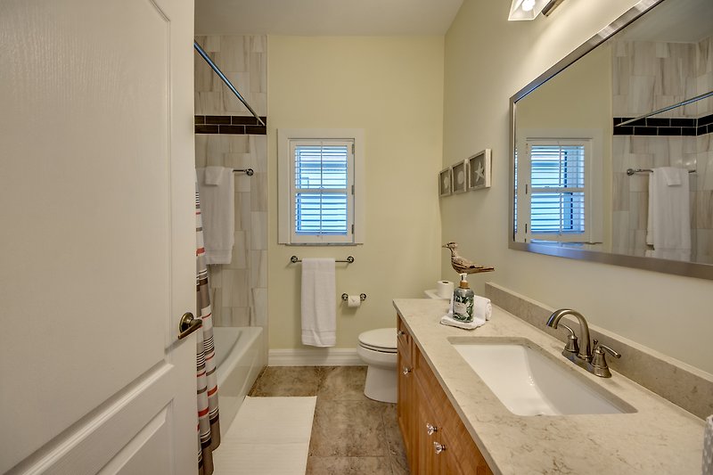 Schönes Badezimmer mit Spiegel, Waschbecken und stilvoller Beleuchtung.