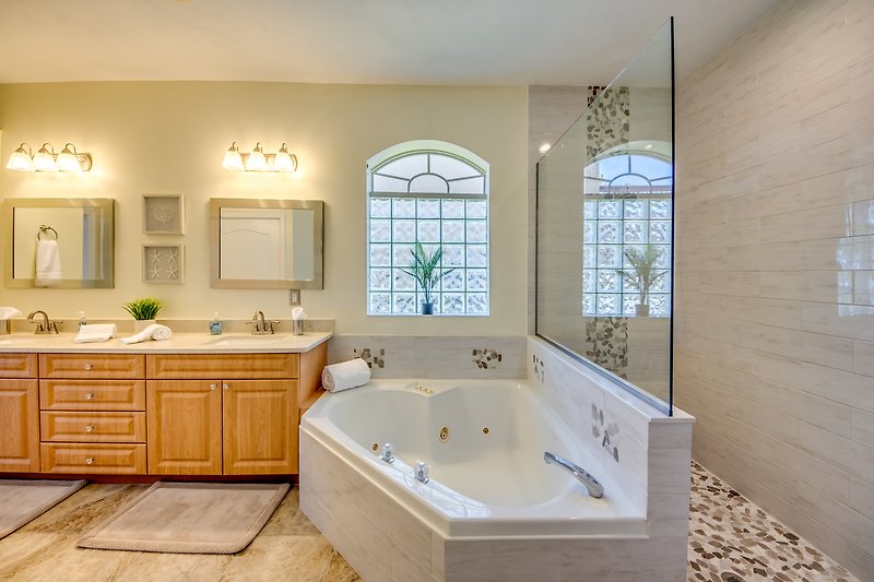 Schönes Badezimmer mit Badewanne, Waschbecken und stilvoller Beleuchtung.
