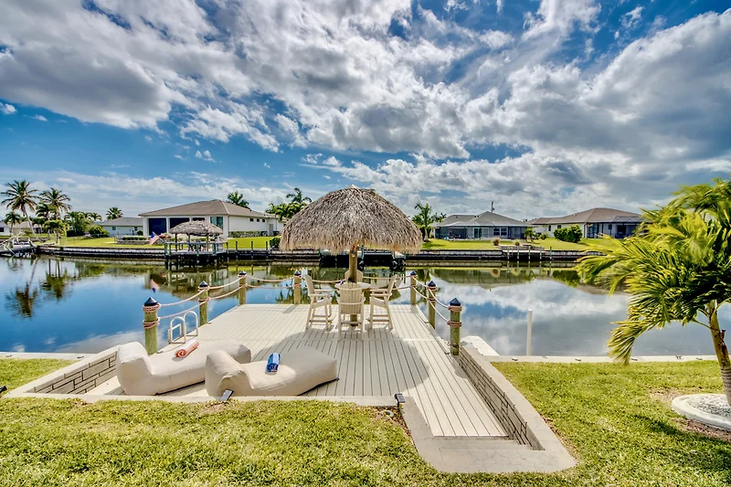 Spiegelnder Teich mit Palmen und Villa im tropischen Eco-Resort.