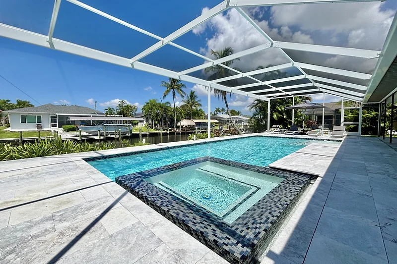 Pool mit Pergola, Outdoor-Lounge, Palmen und nachhaltigen Materialien.