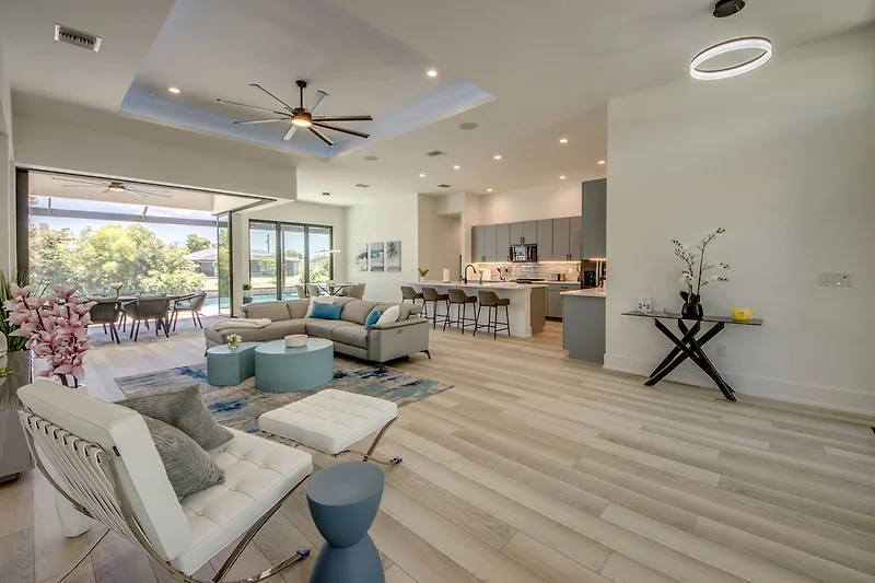 Loft mit Sofa, Sessel, Couchtisch, TV, Deckenventilator und Pflanzen.