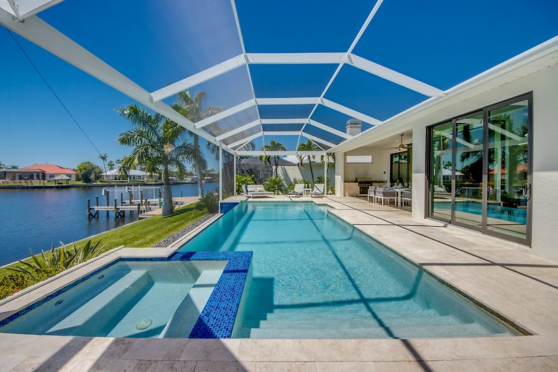 Luxuriöses Schwimmbad mit urbanem Design und Palmen.