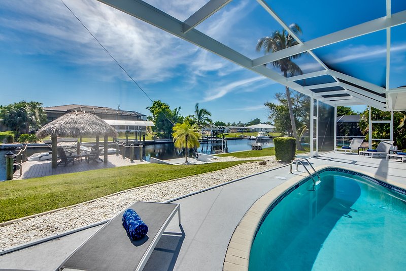 Moderne Ferienwohnung mit Pool, Sonnenliegen und traumhaftem Ausblick auf das Wasser.