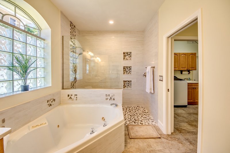 Schönes Badezimmer mit Badewanne, Dusche und Fensterbehandlung.