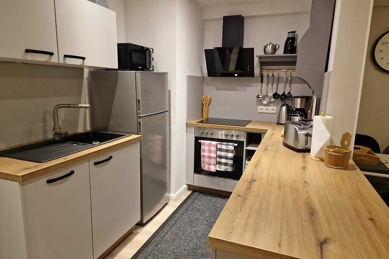 Moderne Küche mit Gasofen, Mikrowelle und Esstisch.