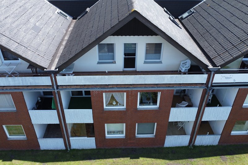 Gemütliches Ferienhaus mit Holzfassade und symmetrischem Design. Perfekt für Urlauber.