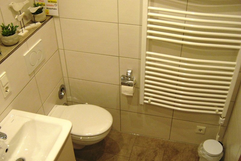 Badezimmer mit lila Toilette, Spiegel und Waschbecken.