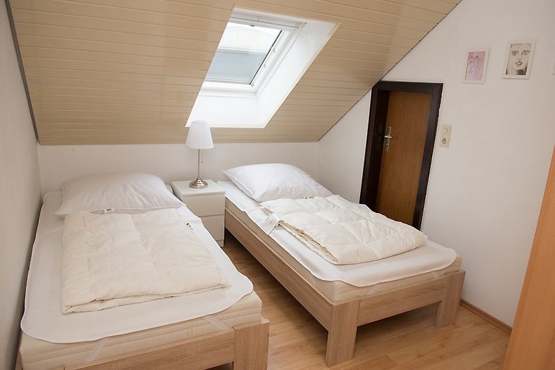 Gemütliches Schlafzimmer mit komfortablem Bett und stilvollem Holzmöbel.