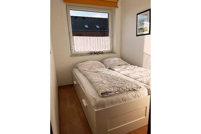 C-19 Schlafzimmer mit stilvollem Bett und Holzmöbeln.