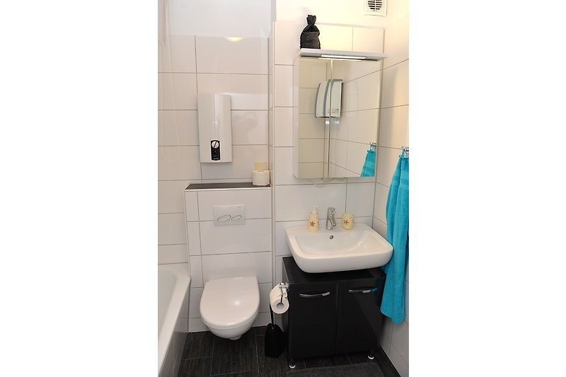 Schwarzes Badezimmer mit stilvollem Design und lila Akzenten.