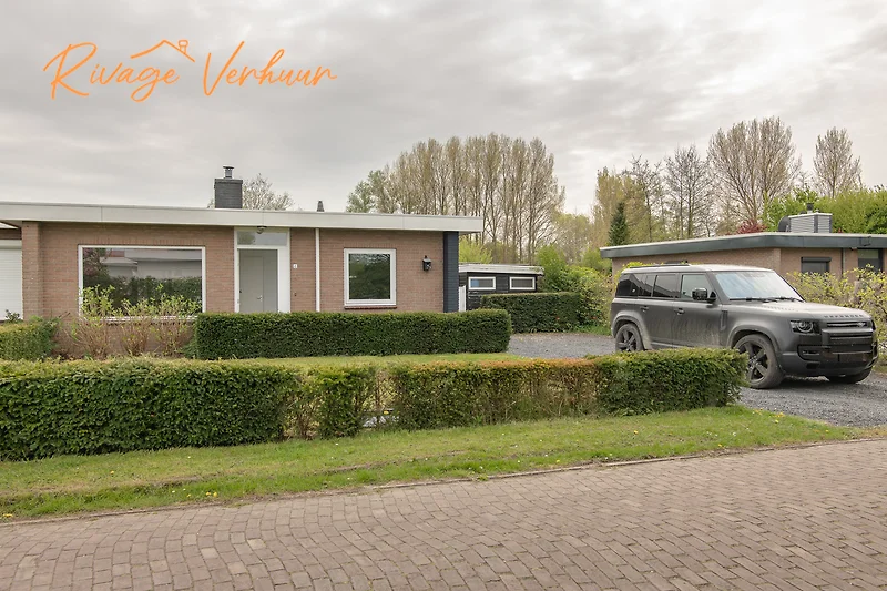 Auffahrt mit geparktem Auto und leuchtendem Rücklicht.