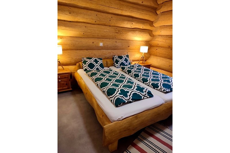 Gemütliches Schlafzimmer mit Holzbett, Kissen, Bettwäsche und Metalldecke.