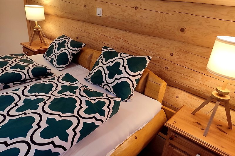Gemütliches Schlafzimmer mit Holzmöbeln und Bettwäsche.