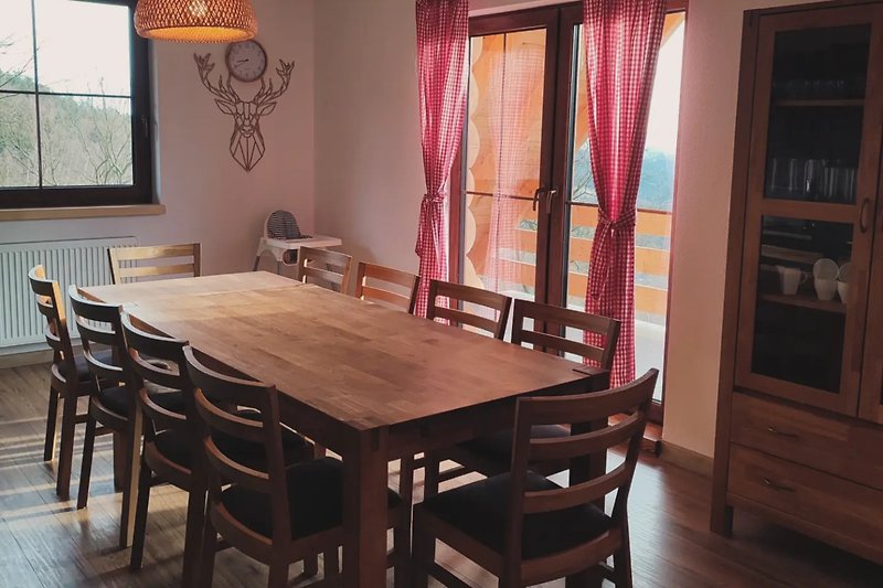 Holzinterieur mit Tisch, Stuhl, Regal und Vorhang.