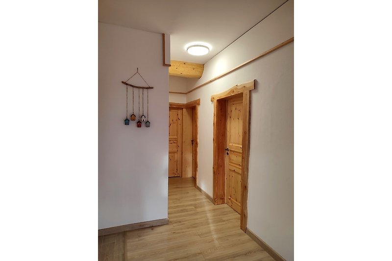 RUDOLF Holzverkleidete Tür mit Beleuchtung und Wandmuster.