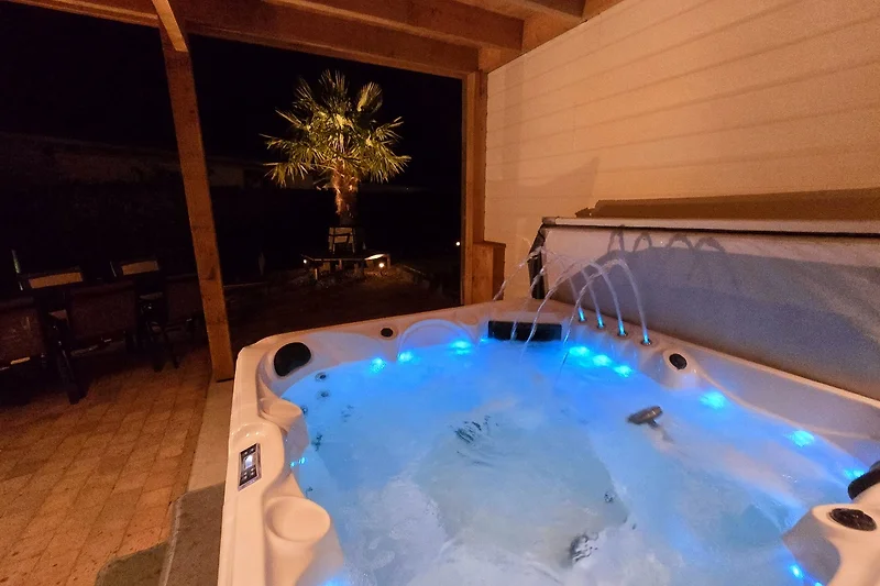 Whirlpool mit Nachtbeleuchtung und entspannender Atmosphäre.