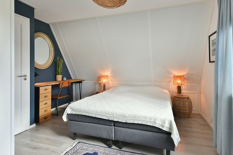 Een comfortabele slaapkamer met een prachtig bed en houten meubels.