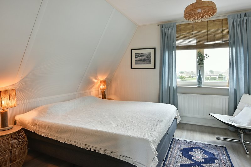 Een comfortabele slaapkamer met houten meubels en sfeervolle verlichting.
