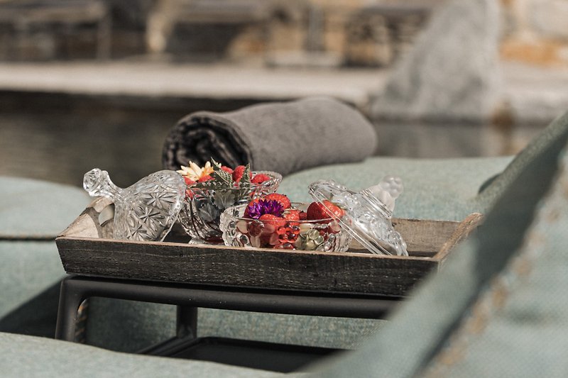 Schöne Blumen und Pflanzen auf einem Holztisch mit grauem Beton. Perfekt für den Urlaub.