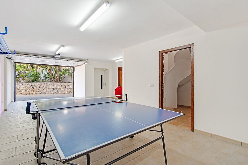 Ping-Pong-Spaß im Haus mit Tischtennisschläger und Tisch.