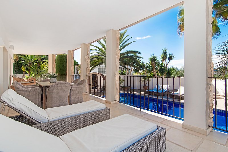 Elegantes Design mit Pool, Palmen und moderner Fassade.