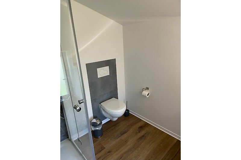 Gemütliches Badezimmer mit Holzboden und stilvoller Einrichtung.