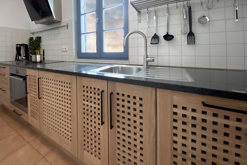 Moderne Küche mit Granit-Arbeitsplatte und Holzboden.
